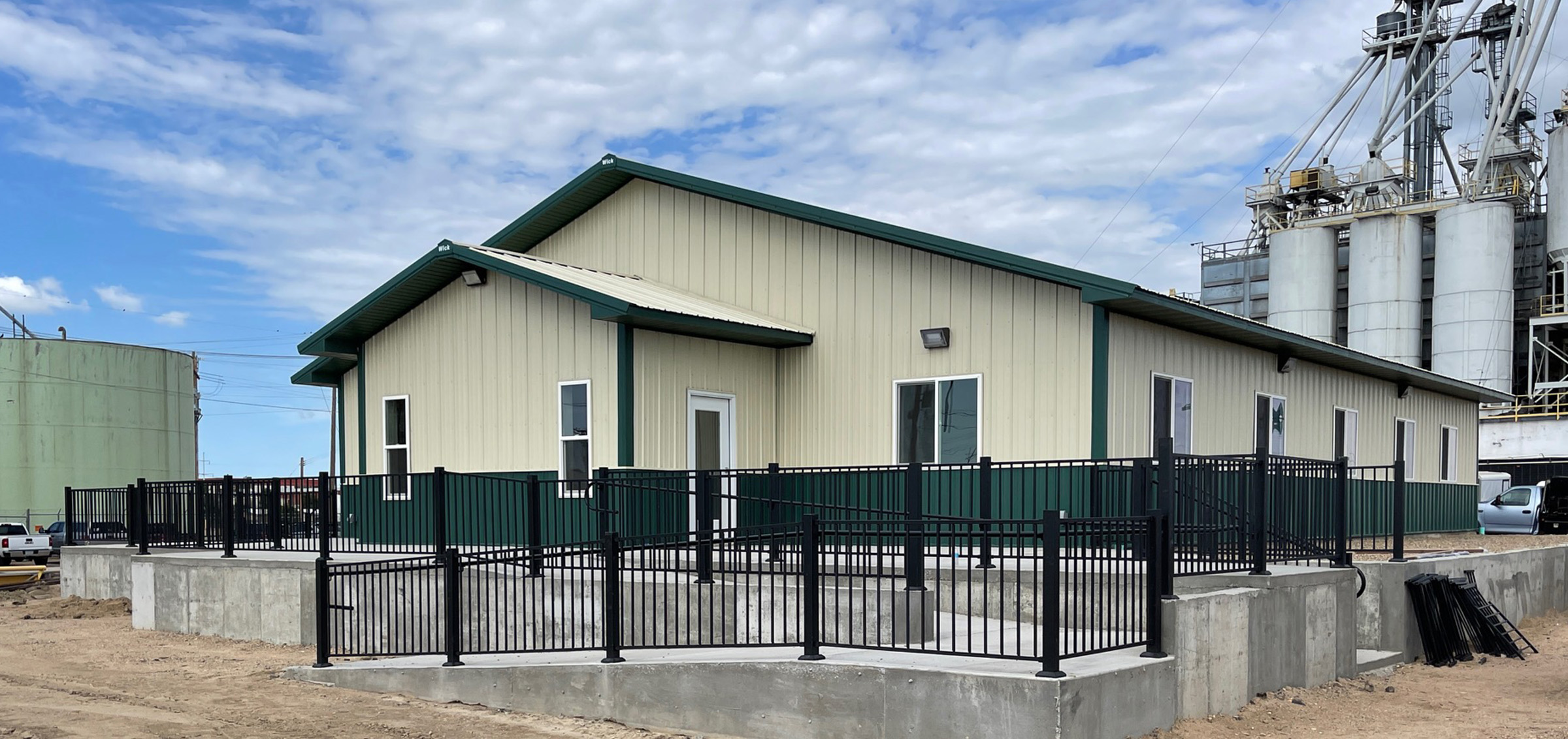 Light yellow and dark green post frame commercial building located in an industrial park