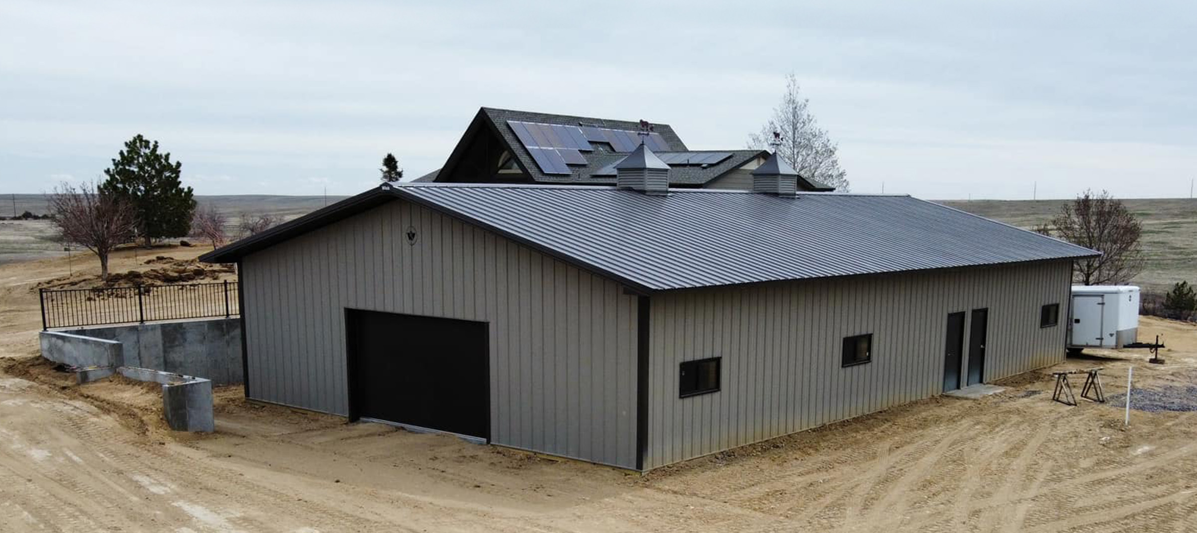Gray and black suburban post frame building