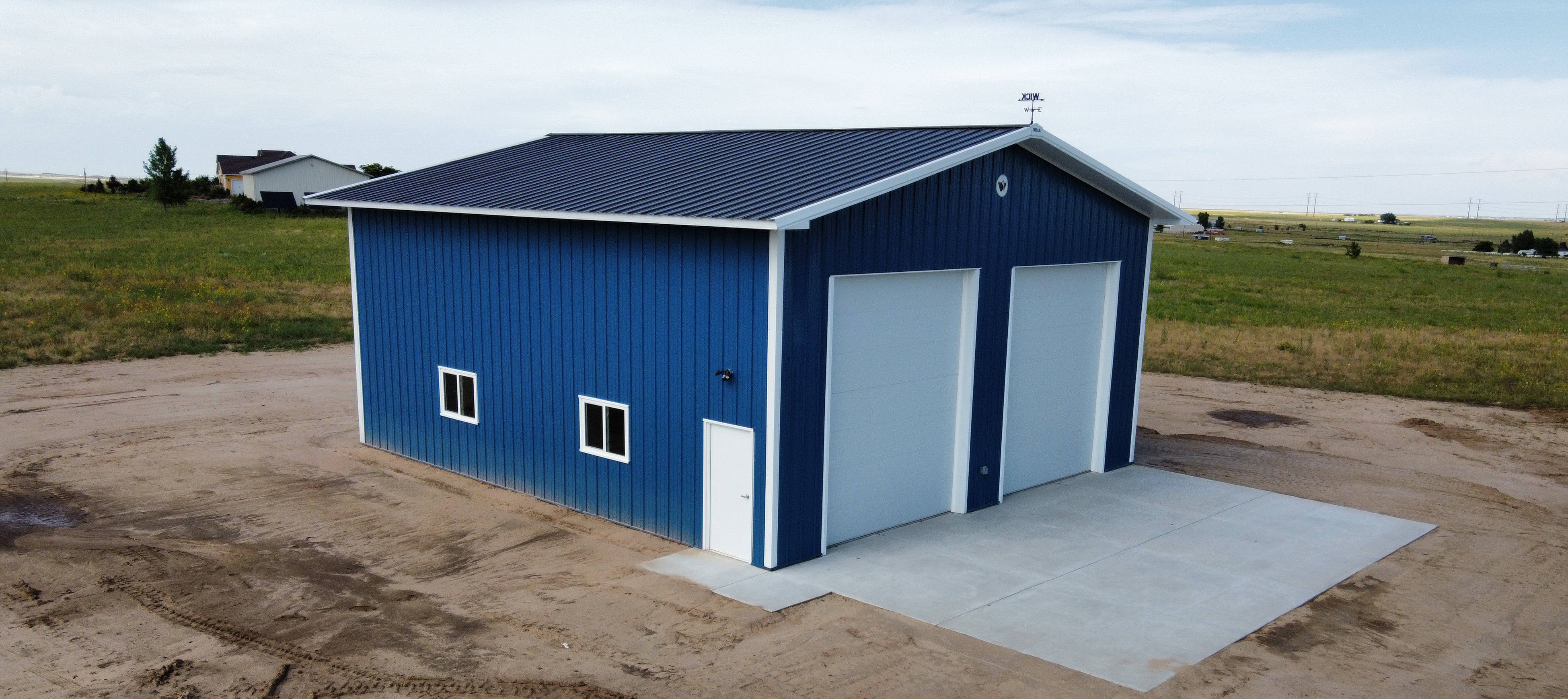 Fat Puppy construction's featured project of a blue and white, two-story suburban post frame building